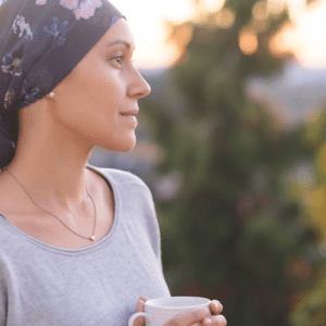 Woman wearing a head wrap looks off in the distance while standing outside